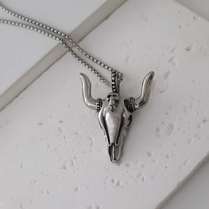 Détail du pendentif crâne de bœuf argenté avec texture vintage et chaîne à mailles box
