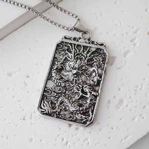Detailed close-up of a carved dragon relief on a rectangular vintage pendant necklace