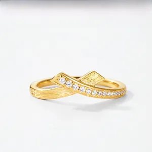 Macro view of golden cross ring featuring sparkling cubic zirconia and brushed texture