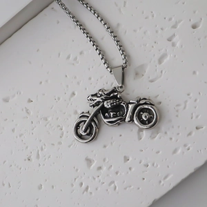 Macro detail of silver punk motorcycle pendant with intricate relief on a box chain