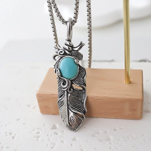 Vintage oxidized silver feather necklace with oval turquoise stone on a box chain