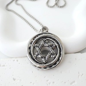 Close-up of vintage silver compass pendant with 3D star of David texture and chain