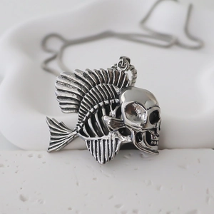 Macro detail of gothic fishbone skull pendant with vintage silver finish on white stone
