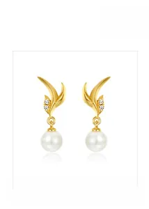 Macro shot of gold leaf earrings with small crystals and glossy white round pearls