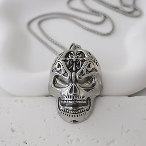 Détail macro du pendentif crâne punk gothique avec emblème de croix en argent vintage