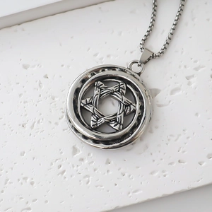 Close-up of vintage silver star of David compass pendant with stainless box chain
