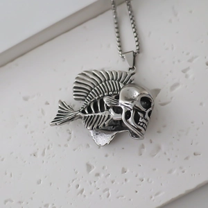 Detailed view of gothic fishbone skull pendant in vintage silver metal and bead chain