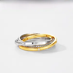 Detail of s925 silver three-tier twisted ring with gold finish and zircon stones