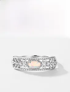 Macro detail of oval opal ring with vintage filigree silver band and tiny zircons