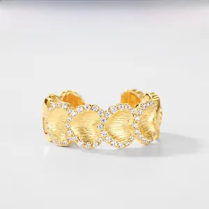 Close-up of heart-shaped gold ring featuring textured finish and sparkling pave crystals