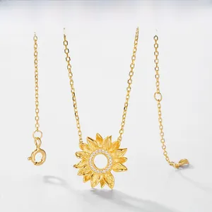 Dettaglio macro del ciondolo a girasole con finitura in oro spazzolato e zirconi