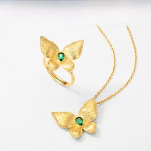 Détail de la parure papillon en or brossé avec pierre verte et accents de diamants