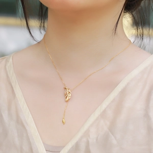 Elegant gold leaf feather necklace with micro-paved zircons on minimalist Y-chain