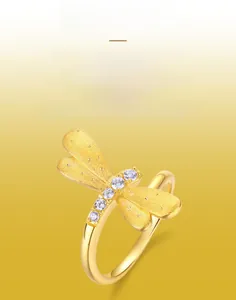 Detailed close-up of dragonfly ring with brushed gold wings and white zircon body