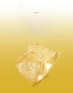 Detail of handcrafted brushed texture gold ring with irregular wavy edges and small zircon