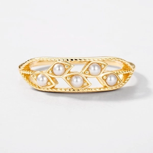 Vintage gold hollow leaf ring with pearls and twisted rope edges on white background