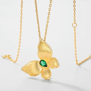 Pendentif papillon doré brossé avec émeraude et bordure en diamant sur chaîne fine en or