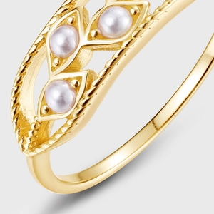 Macro detail of gold vintage ring featuring three pearls in marquise twisted metal settings