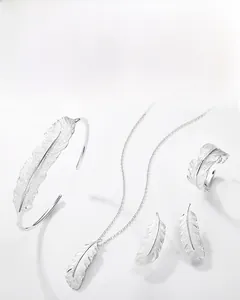 Detailed macro view showing brushed metal texture of the silver feather jewelry collection