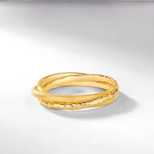 Macro detail of triple interlocking rings featuring polished, frosted, and hammered textures