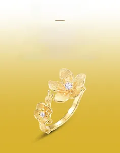 Detail of handcrafted brushed gold floral ring featuring purple zircon flower centers