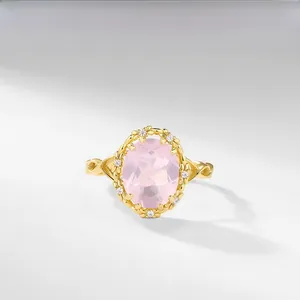 Detail of vintage gold ring with large pink oval gemstone and floral accents