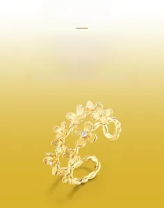 Détail d'une bague florale artisanale en or brossé avec des accents de zircon
