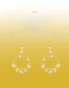 Detail of handmade brushed gold floral earrings with sparkling white crystals