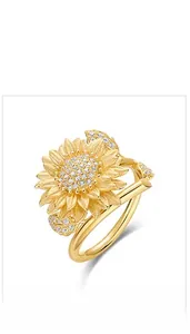 Macro shot of handcrafted brushed gold sunflower ring with sparkling zircon inlays