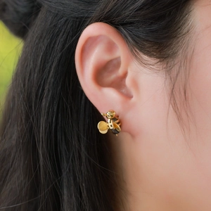 Boucles d'oreilles abeille en argent S925 avec œil de tigre portées par un mannequin