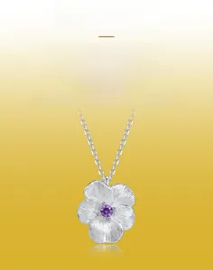 Detailed view of brushed silver floral pendant with a central purple zircon stone