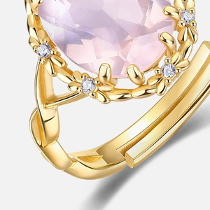 Macro detail of gold-plated S925 silver ring featuring pink crystal and floral accents