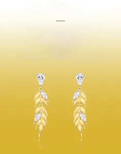 Detailed view of handmade brushed gold wheat earrings with drop-shaped cubic zirconia stones