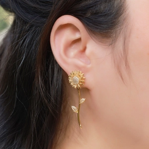 Brushed gold sunflower earrings with micro-pave crystals on a model for elegant look