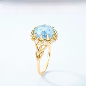 Détail d'une bague en argent doré avec une grande topaze bleue et de petits diamants