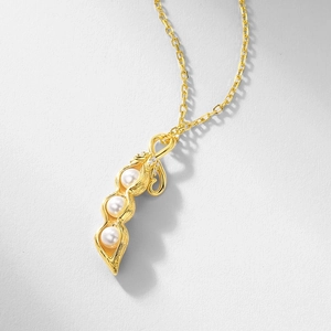 Élégant collier pendentif cosse de pois doré avec trois perles blanches sur fond gris