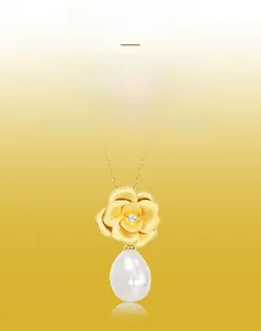 Macro detail of hand-brushed gold rose pendant with small diamond and drop pearl