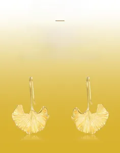 Macro detail of handmade brushed texture on golden ginkgo leaf dangle earrings