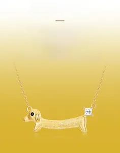 Détail du collier teckel doré montrant la texture brossée et la pierre de zircone sertie