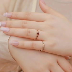 Vintage gold garnet ring set with lace hollow design and red stone on silk background