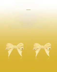 Detailed view of handmade brushed golden bow earrings with intricate linear texture