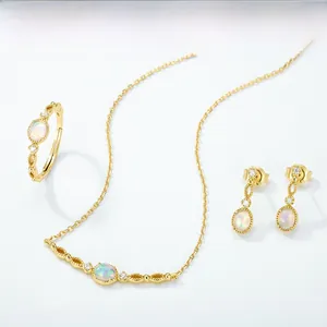 Detail of vintage 18K gold plated oval opal jewelry set with intricate filigree and zircons