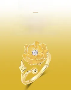 Detail of s925 gold-plated peony ring showing brushed metal petals and center crystal
