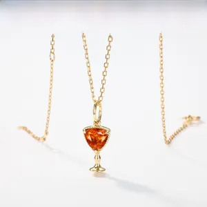 Detail of S925 silver gold-plated necklace with triangle orange gemstone pendant