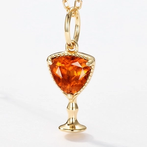 Elegant gold cocktail glass pendant with vibrant triangular orange gemstone and thin chain