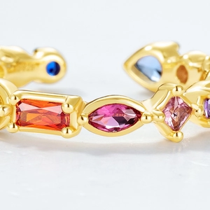 Macro view of gold adjustable ring featuring vibrant multi-colored inlaid gemstones