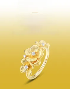 Macro detail showing handmade brushed gold texture and jasmine flower with zircon stones