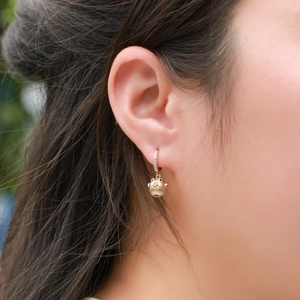Boucles d'oreilles oiseau en argent S925 doré avec pierres portées par un modèle