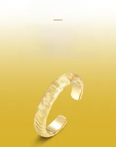 Macro detail of gold brushed texture and polished inner band of the open cuff ring
