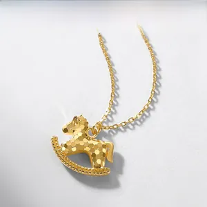 Gros plan du pendentif cheval à bascule doré avec texture alvéolée et chaîne fine élégante